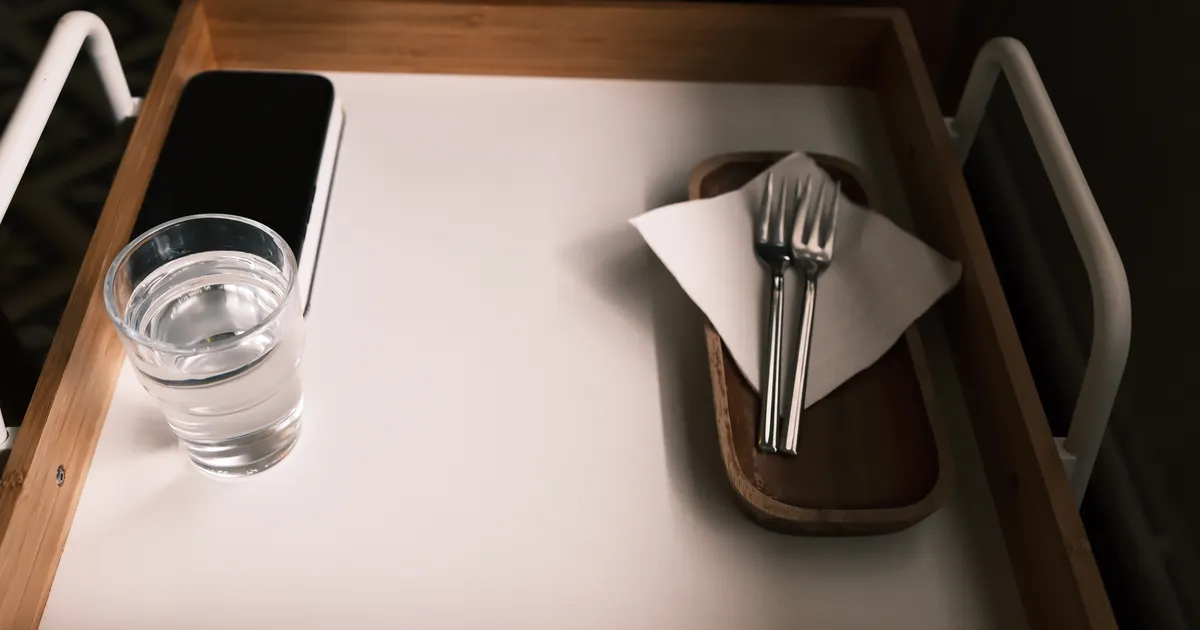 トレーに置かれた水のグラスとフォーク