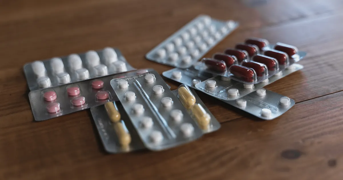 木の台に置かれた、シートに入った錠剤とカプセル