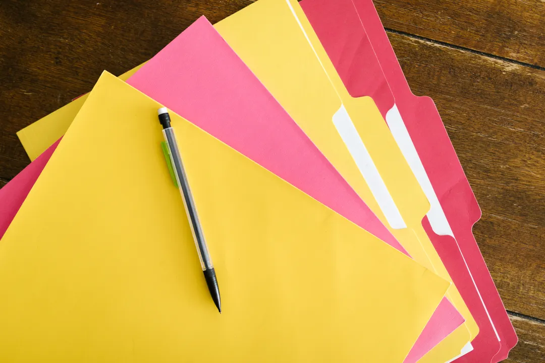机の上に置かれたファイルとペン