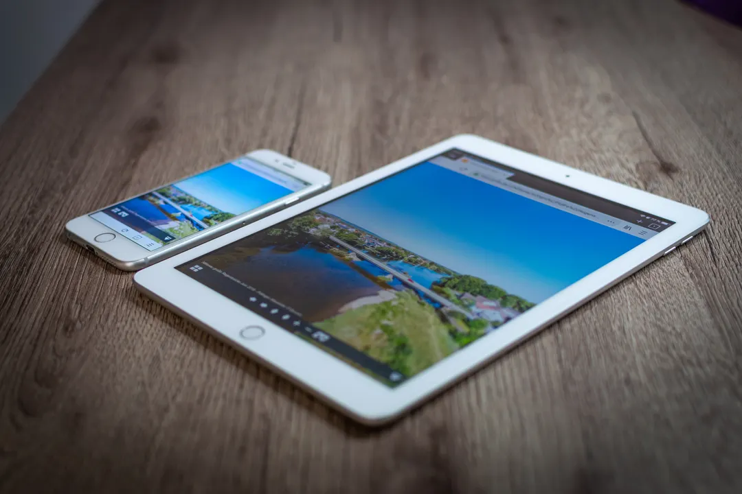 木の机に置かれたタブレットとスマートフォン