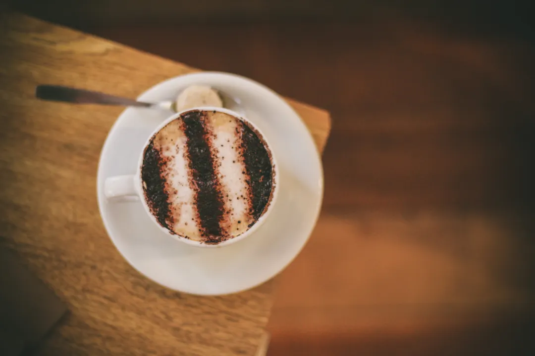木のテーブルに置かれたコーヒーカップ